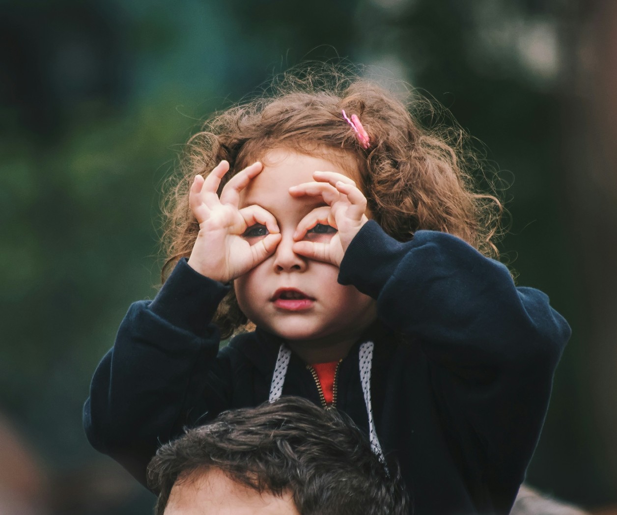 Memoir author looking for a theme depicted as a little girl with binoculars