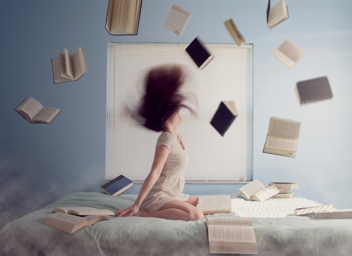 Woman sitting on bed with books flying around her because they need to professionalize the memoir writing.