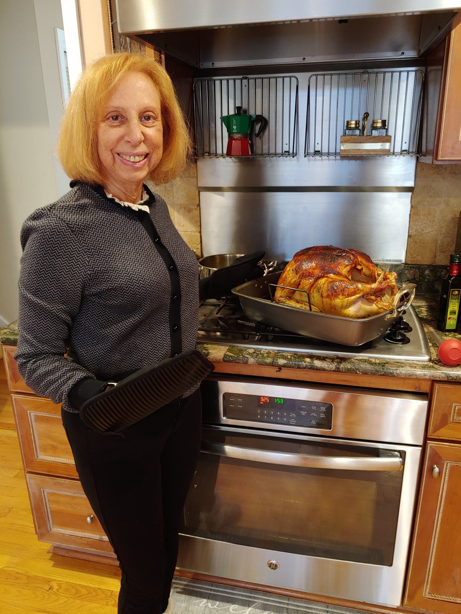 Rosanne at the oven showing her Thanksgiving turkey