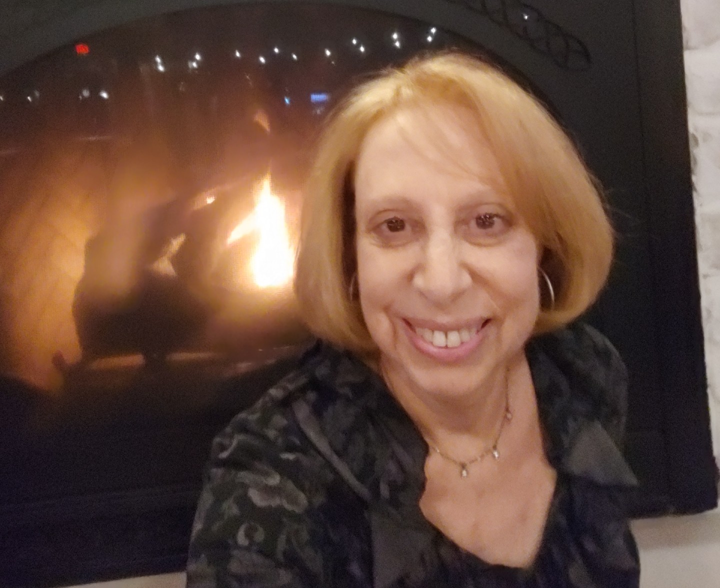Rosanne in front of a fire at a restaurant