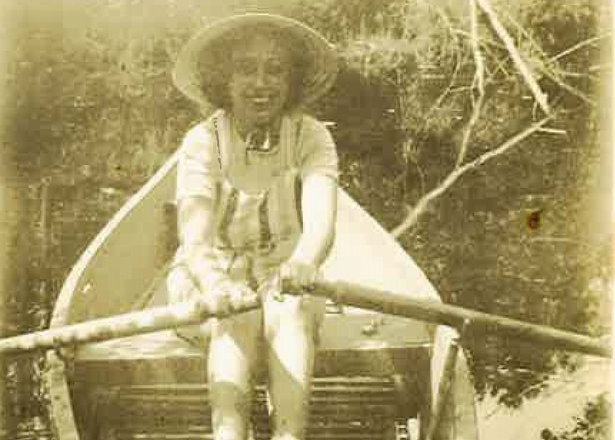 Old photo in a memoir of woman paddling a canoe