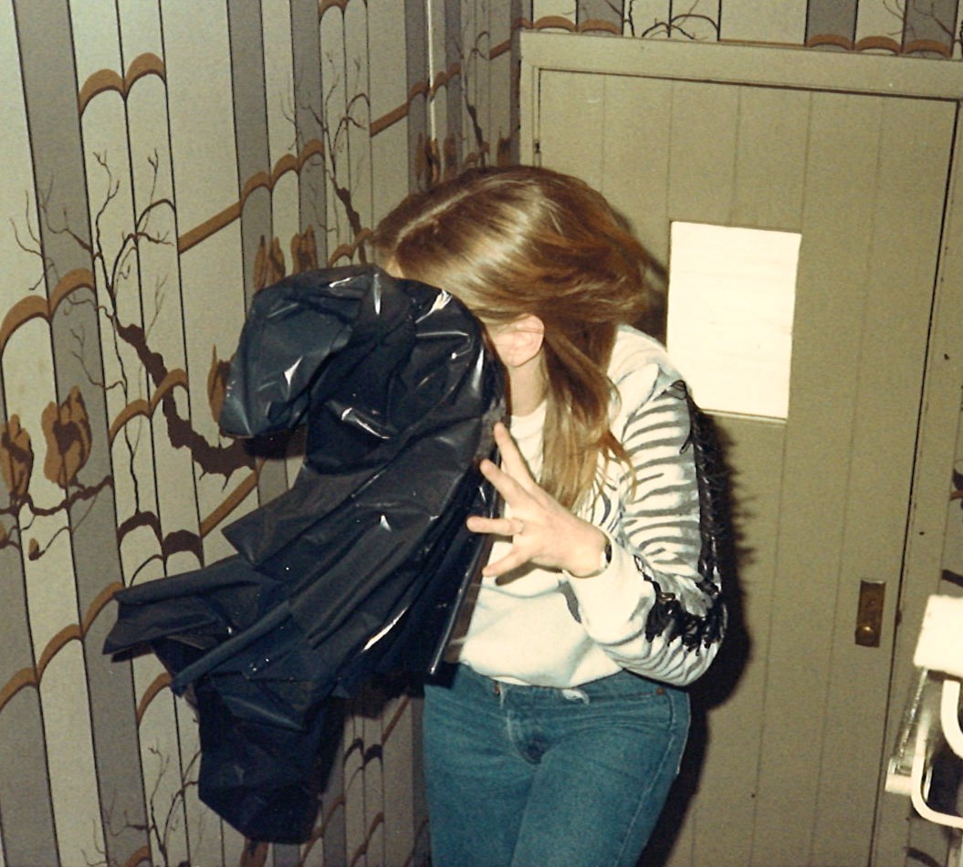 Young woman hiding her face behind a black trash bag